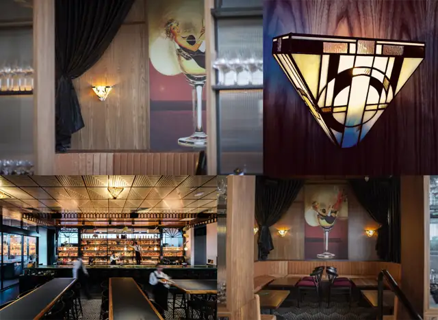 Applique murale Art Déco de style Tiffany, de forme trapézoïdale et en verre teinté. Le motif géométrique présente des lignes droites et des formes circulaires dans une palette de couleurs dominée par le blanc laiteux, le jaune ambre et le noir, avec des touches de verre texturé. La lumière chaude émise par l'applique crée un éclairage mural à la fois vers le haut et le bas, mettant en valeur son design géométrique et ses couleurs.