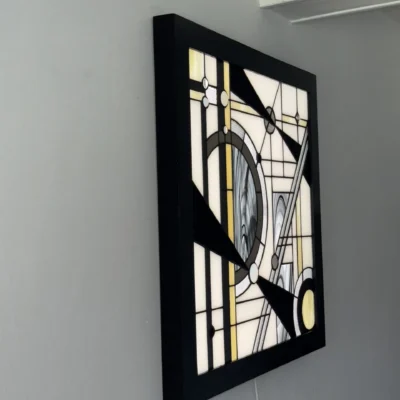 Tableau lumineux en vitrail Tiffany de style Art Déco, aux formes géométriques et verres opalescents, encadré de bois sombre et éclairé par une dalle LED.