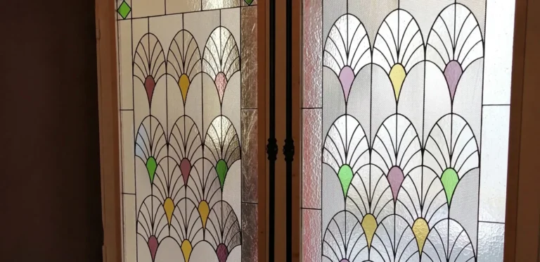 Vitrail Art Déco géométrique avec motifs éventail et verres colorés installé dans une porte intérieure