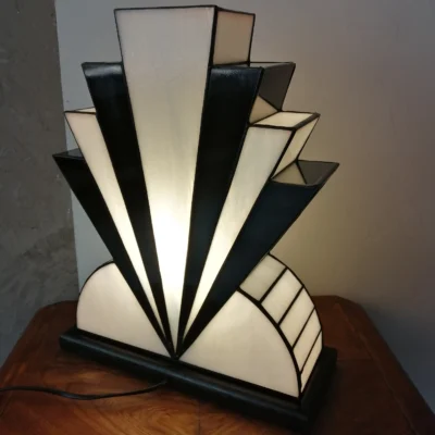 Lampe Art Déco artisanale en vitrail opalescent blanc et noir laqué avec touche de verre or, posée sur un socle en chêne massif sculpté.