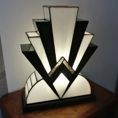 Lampe Art Déco artisanale en vitrail opalescent blanc et noir laqué avec touche de verre or, posée sur un socle en chêne massif sculpté.