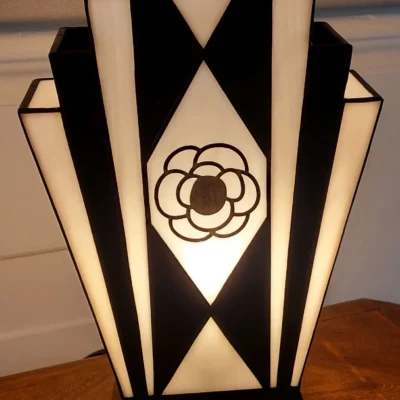 Lampe Art Déco en vitrail Tiffany noir et blanc avec motif camélia peint à la grisaille, verres opalescents et socle en chêne massif sculpté.