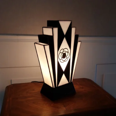 Lampe Art Déco en vitrail Tiffany noir et blanc avec motif camélia peint à la grisaille, verres opalescents et socle en chêne massif sculpté.