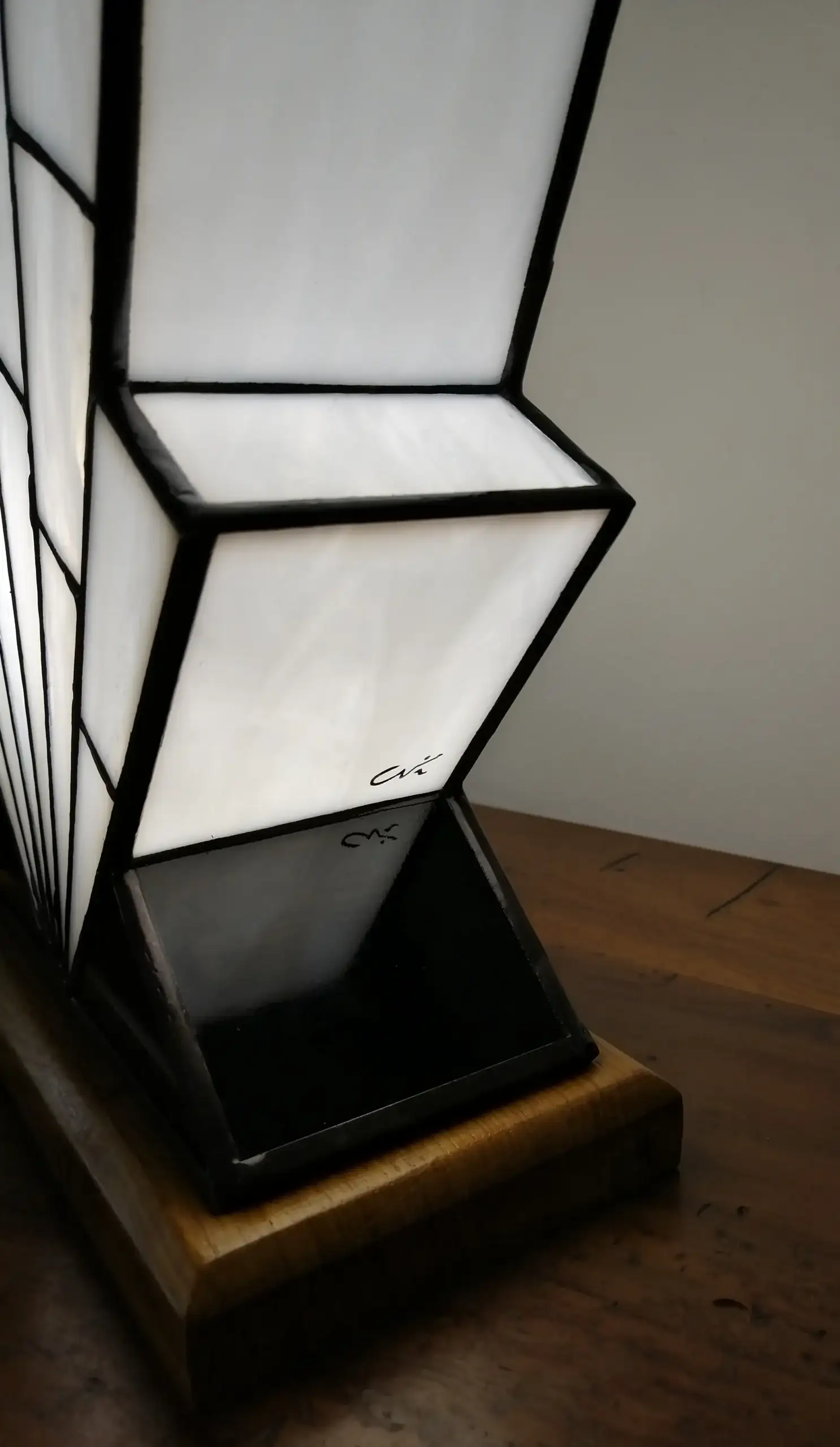 Lampe Art Déco en vitrail opalescent blanc, pied en verre noir et socle en chêne massif sculpté.