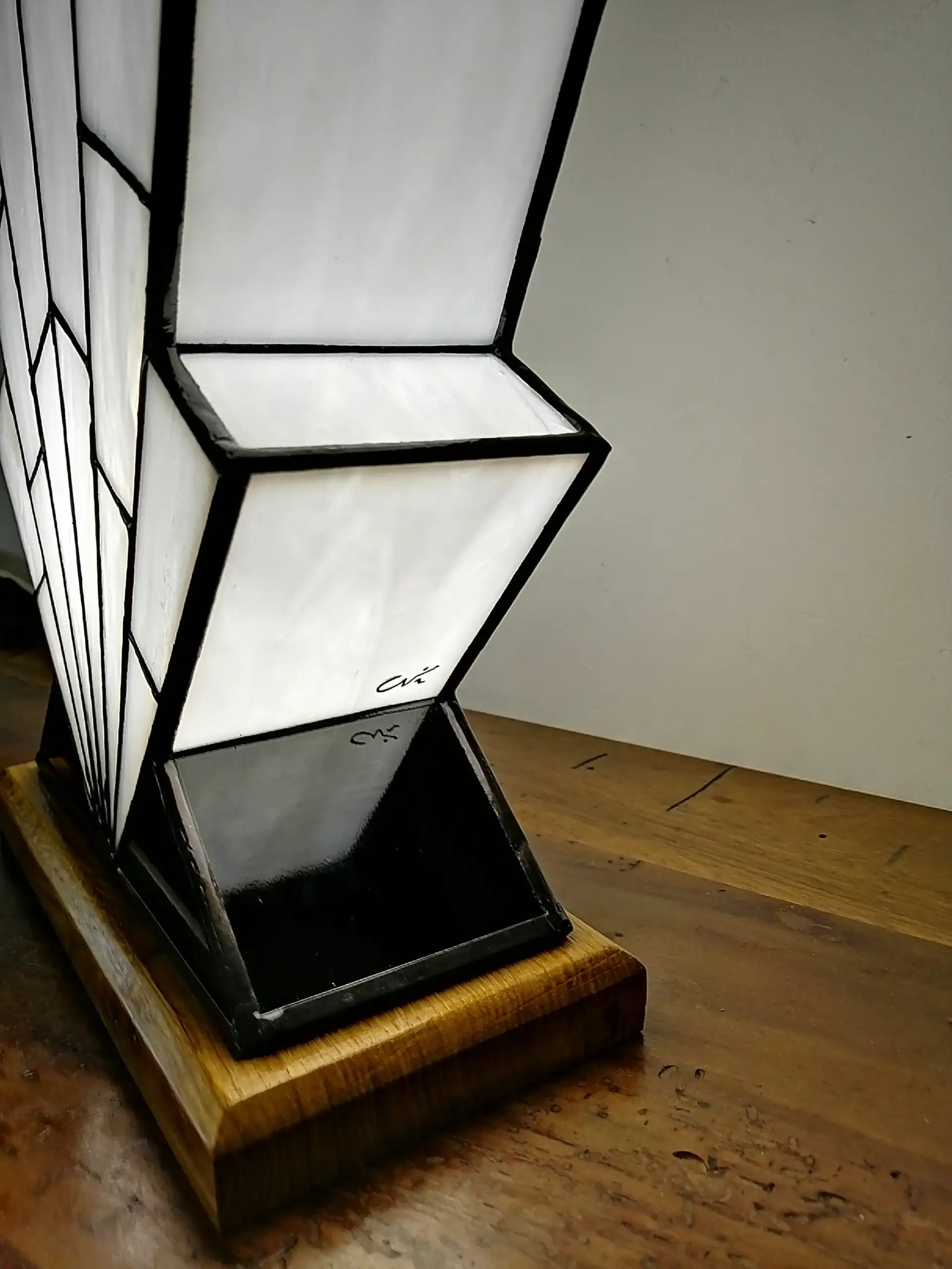 Lampe Art Déco en vitrail opalescent blanc, pied en verre noir et socle en chêne massif sculpté.