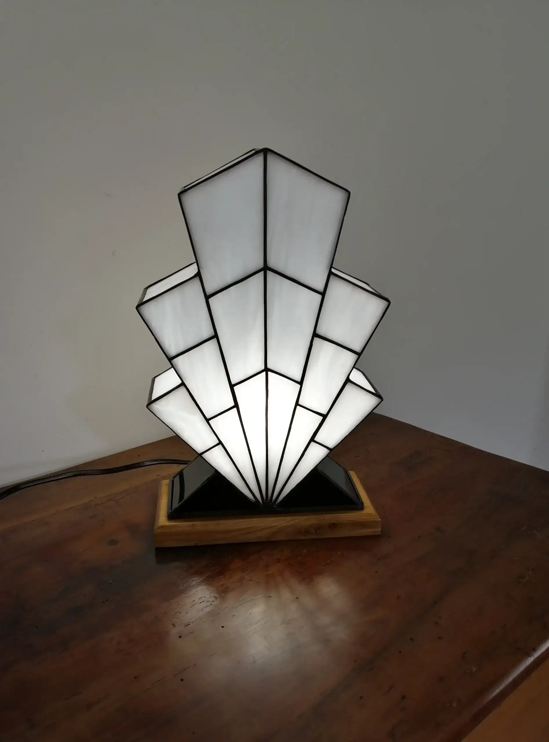 Lampe Art Déco en vitrail opalescent blanc, pied en verre noir et socle en chêne massif sculpté.