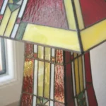 Lampe Art Déco Tiffany en vitrail rouge et multicolore, fabriquée à la main, avec socle en chêne massif sculpté.