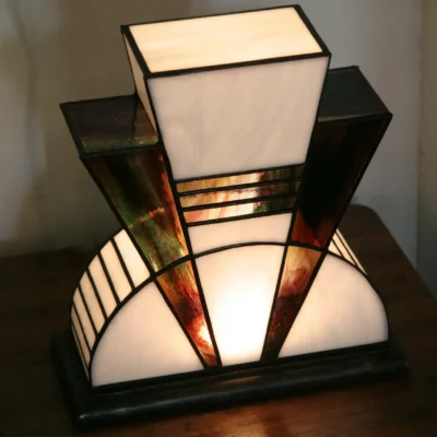 Lampe artisanale en verre opalescent blanc et pourpre, striée de vert et de bleu, à l’aspect poudré et légèrement vieilli, diffusant une lumière douce et chaleureuse.