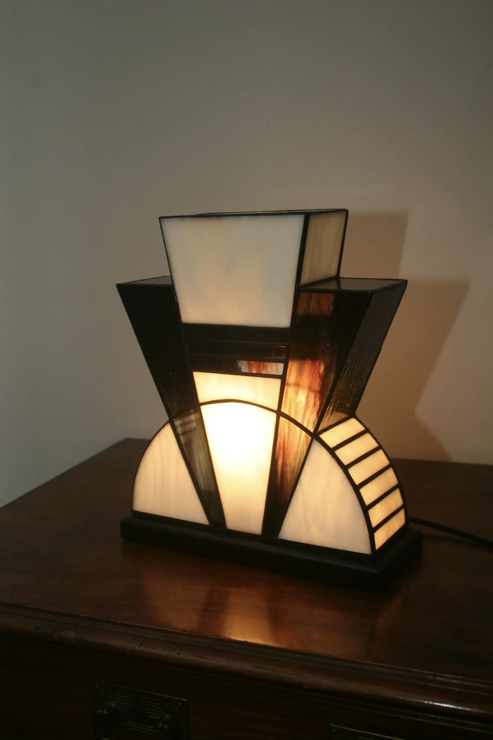 Lampe artisanale en verre opalescent blanc et pourpre, striée de vert et de bleu, à l’aspect poudré et légèrement vieilli, diffusant une lumière douce et chaleureuse.