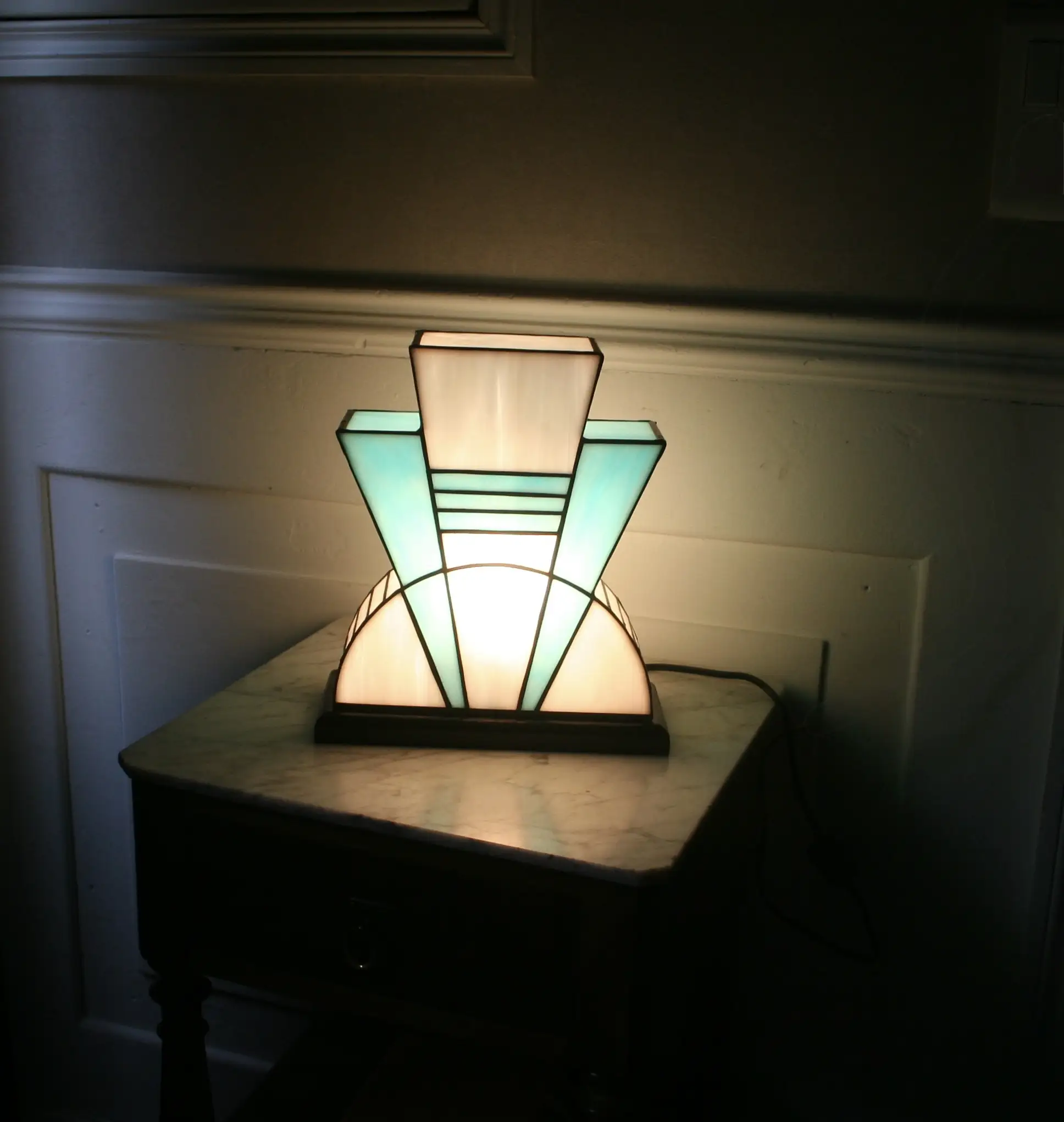 Lampe artisanale en verre opalescent blanc et bleu turquoise, finition antique, sur socle en chêne massif sculpté noir.