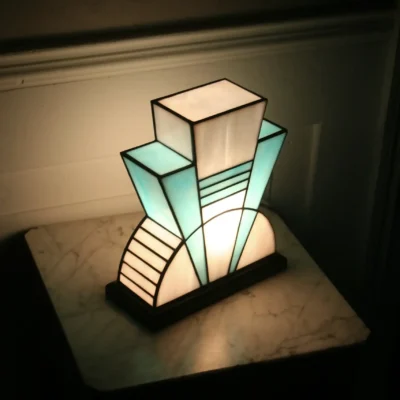 Lampe artisanale en verre opalescent blanc et bleu turquoise, finition antique, sur socle en chêne massif sculpté noir.