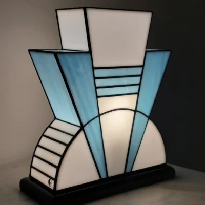Lampe Art Déco vitrail Tiffany 1926 bleu baltique et blanc, verre opalescent géométrique, socle en chêne massif sculpté noir, fabrication artisanale française.