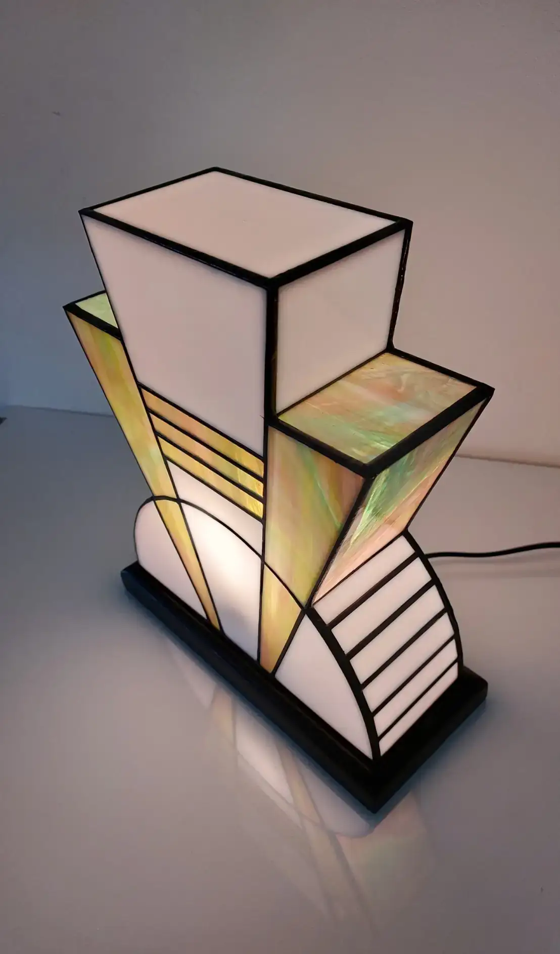 Lampe Art Déco vitrail Tiffany 1926 Boréale multicolore, verre opalescent vert, rose, turquoise et blanc, socle en chêne massif noir patiné, fabrication artisanale française.