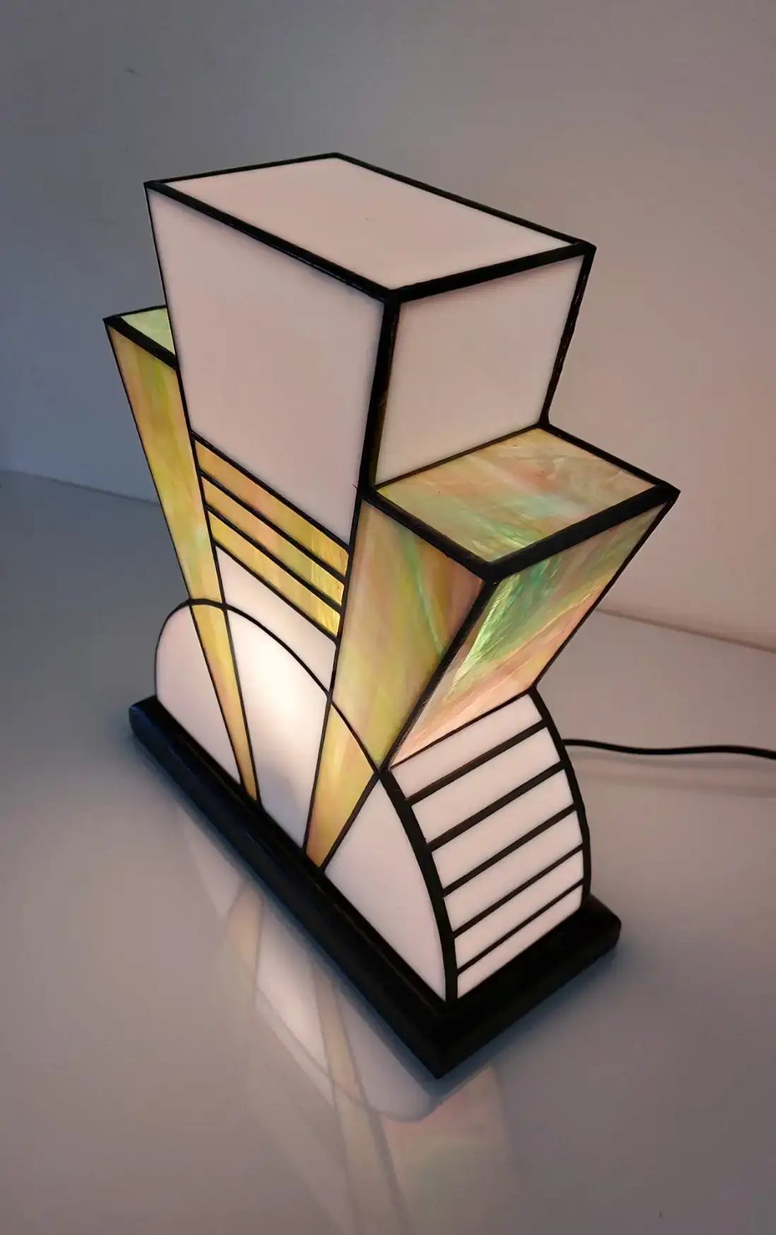 Lampe Art Déco vitrail Tiffany 1926 Boréale multicolore, verre opalescent vert, rose, turquoise et blanc, socle en chêne massif noir patiné, fabrication artisanale française.