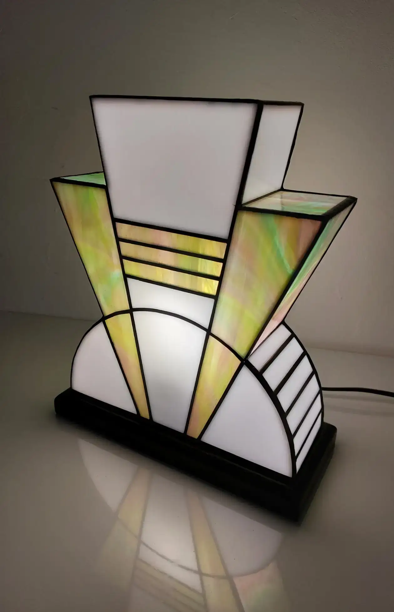 Lampe Art Déco vitrail Tiffany 1926 Boréale multicolore, verre opalescent vert, rose, turquoise et blanc, socle en chêne massif noir patiné, fabrication artisanale française.