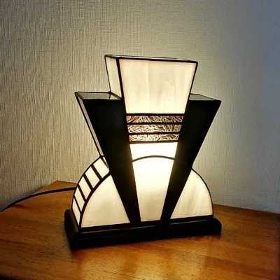 Lampe Art Déco en vitrail Tiffany blanc opalescent et noir glacé avec incrustation dorée à palmettes, socle en chêne massif noir patiné, création artisanale faite main.