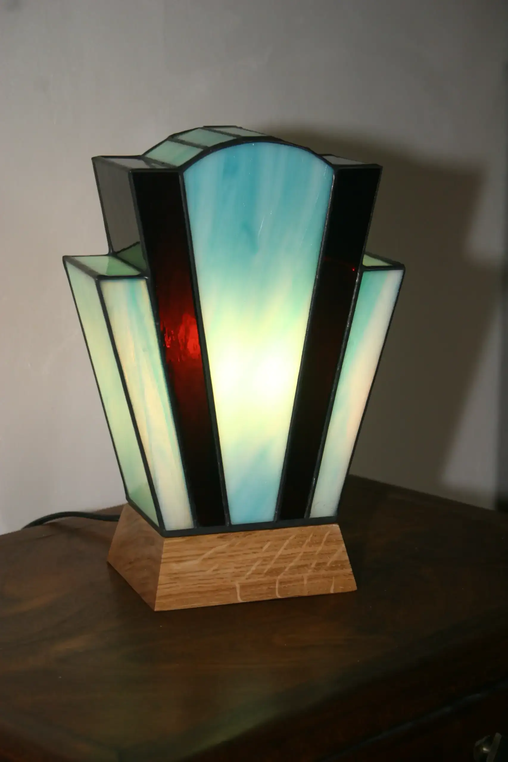 Lampe Art Déco en vitrail Tiffany turquoise lumineux et pourpre profond, socle en chêne massif doré, création artisanale faite main.