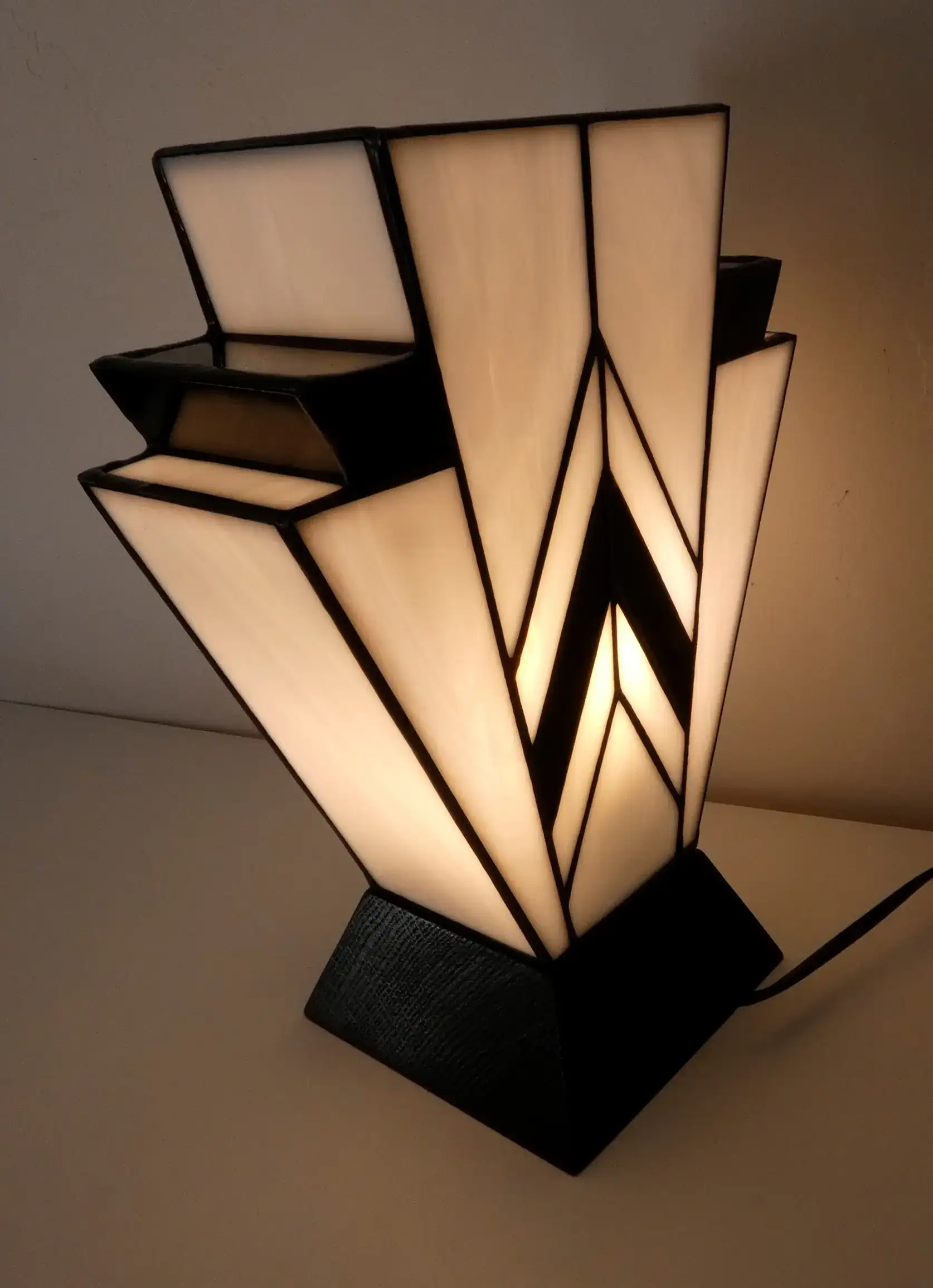 Lampe Art Déco en vitrail Tiffany blanc et noir, motif géométrique 1931, verres opalescents et socle en chêne massif noir sculpté.