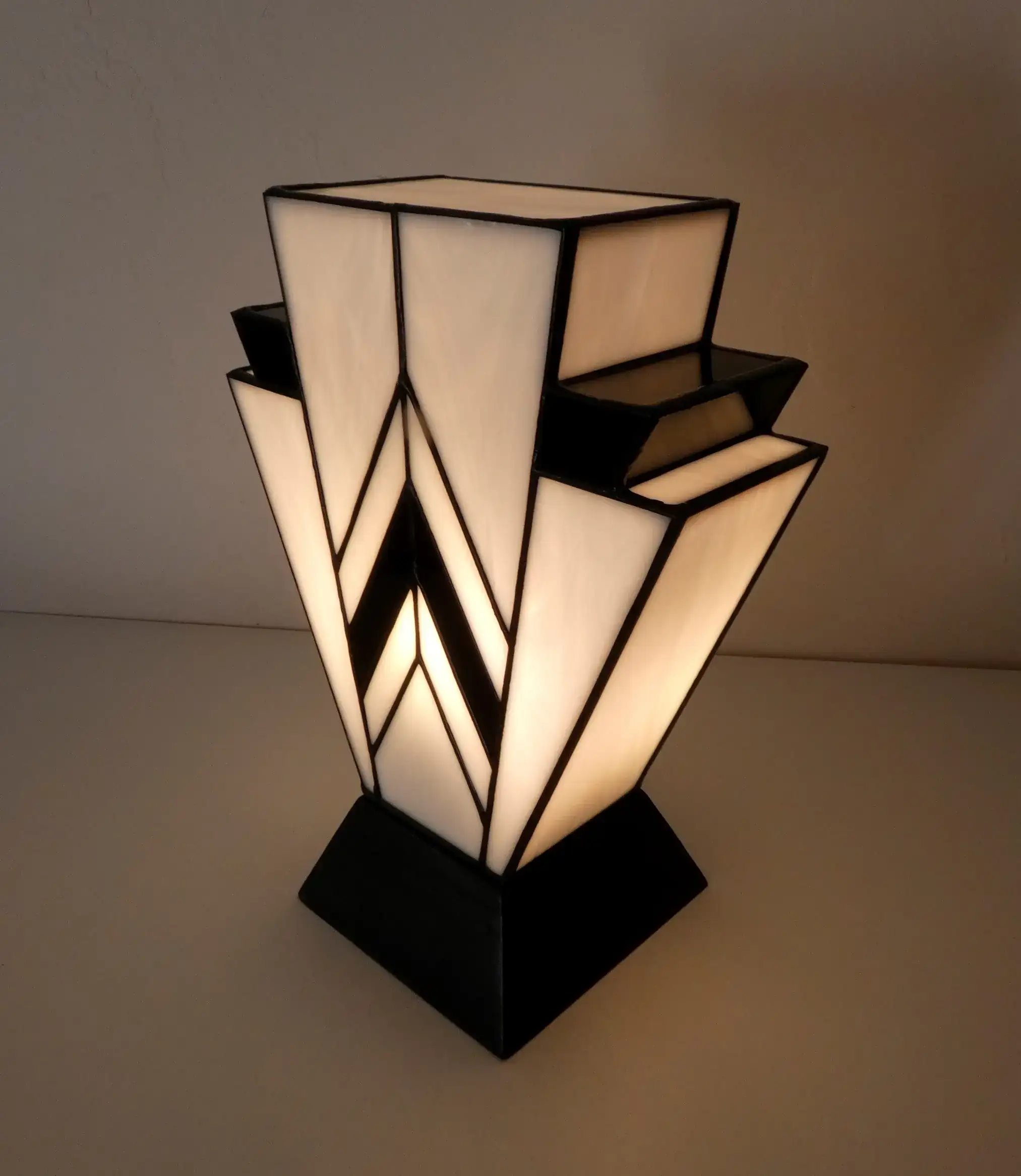 Lampe Art Déco en vitrail Tiffany blanc et noir, motif géométrique 1931, verres opalescents et socle en chêne massif noir sculpté.