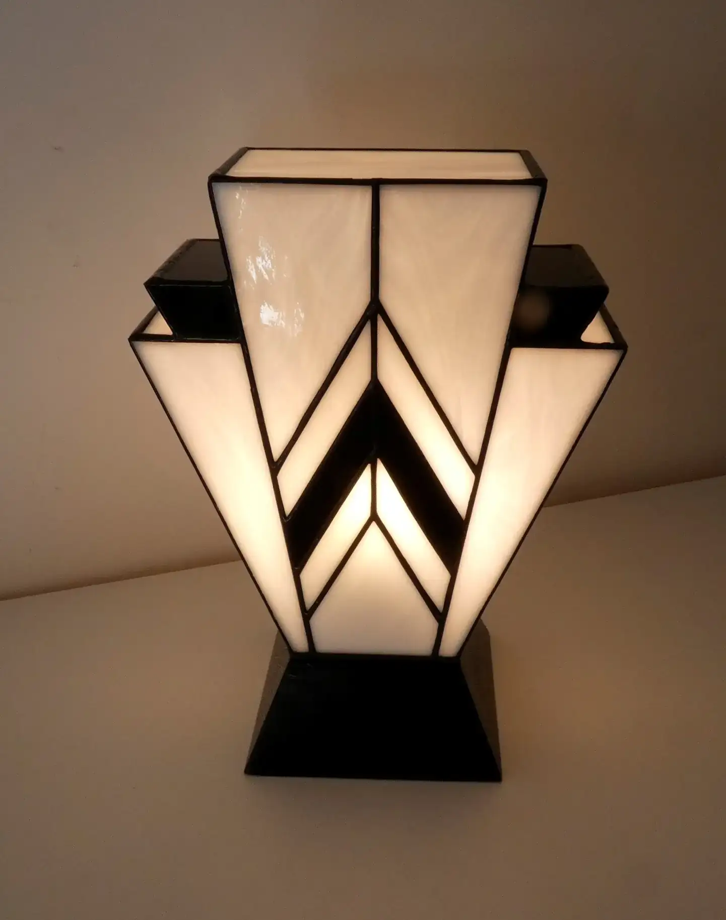Lampe Art Déco en vitrail Tiffany blanc et noir, motif géométrique 1931, verres opalescents et socle en chêne massif noir sculpté.