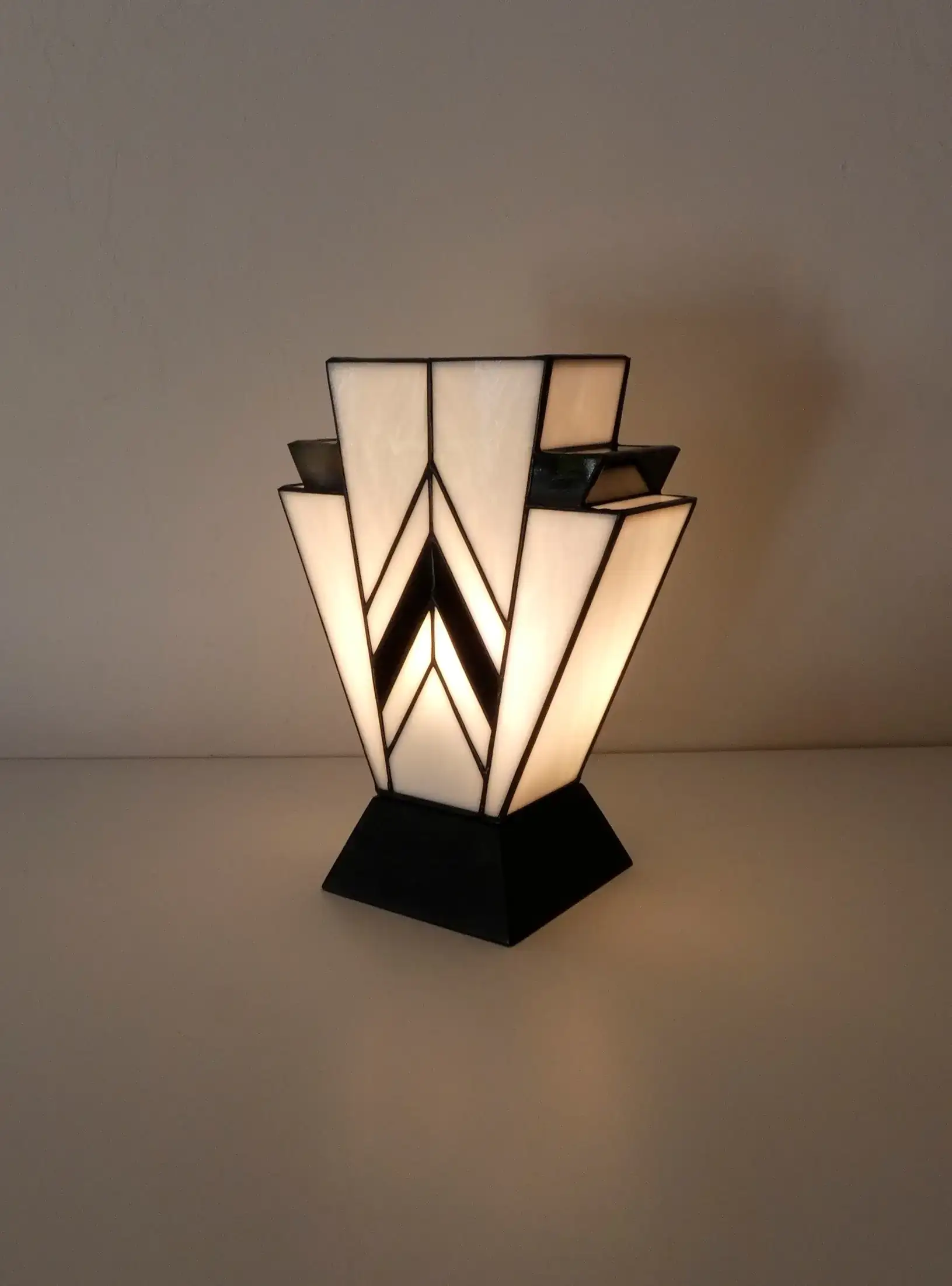Lampe Art Déco en vitrail Tiffany blanc et noir, motif géométrique 1931, verres opalescents et socle en chêne massif noir sculpté.